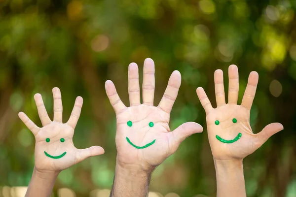 Målade Smiley Ansikte Handflatorna Mot Våren Grön Suddig Bakgrund Familjefirande — Stockfoto