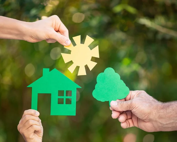 Família Segurando Casa Mãos Contra Fundo Verde Primavera Imobiliário Conceito — Fotografia de Stock