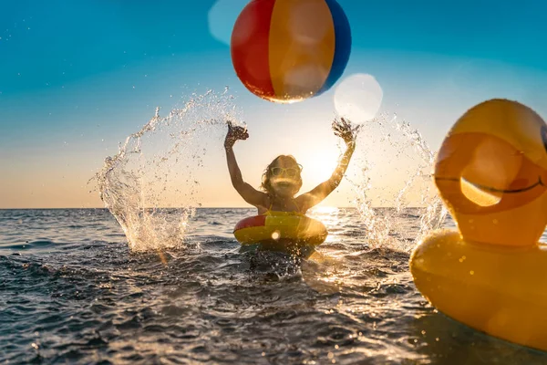 夏休みを楽しんでいる幸せな子供 海でゴム製のアヒルやボールと遊ぶ子供 健康的なライフスタイルのコンセプト 春休み — ストック写真