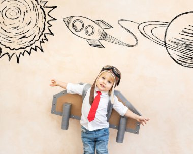 Mutlu çocuk astronot gibi davranıyor. Evde oynayan komik çocuk. Rüya ve hayal gücü kavramı