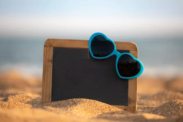 沙质海滩上的黑板空白和太阳镜 暑假的概念 — 图库照片