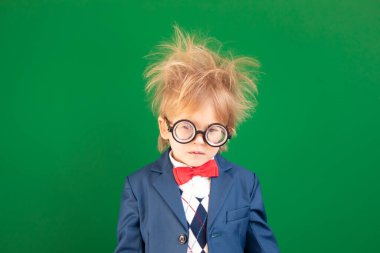 Parlak fikir! Sınıftaki komik çocuk öğrenci. Ciddi çocuk yeşil tahtaya karşı. Çevrimiçi eğitim ve e-öğrenme kavramı. Okula geri dön.