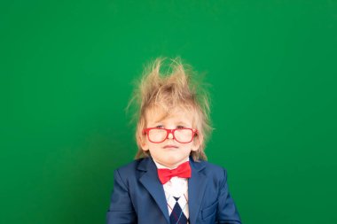 Parlak fikir! Sınıftaki komik çocuk öğrenci. Yeşil karatahtaya karşı kafası karışık çocuk. Çevrimiçi eğitim ve e-öğrenme kavramı. Okula geri dön.