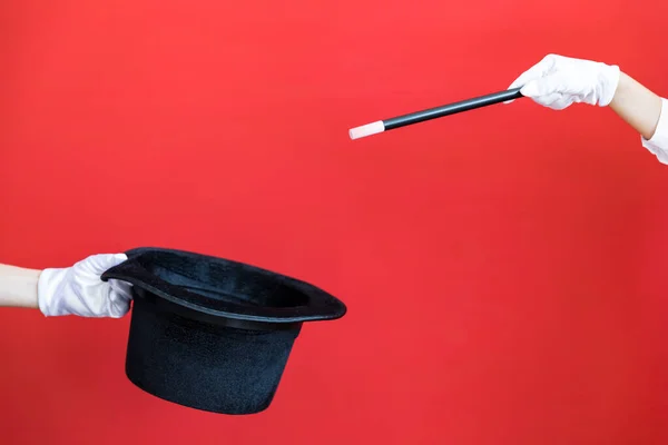 红色背景下的魔杖和黑色顶帽 — 图库照片