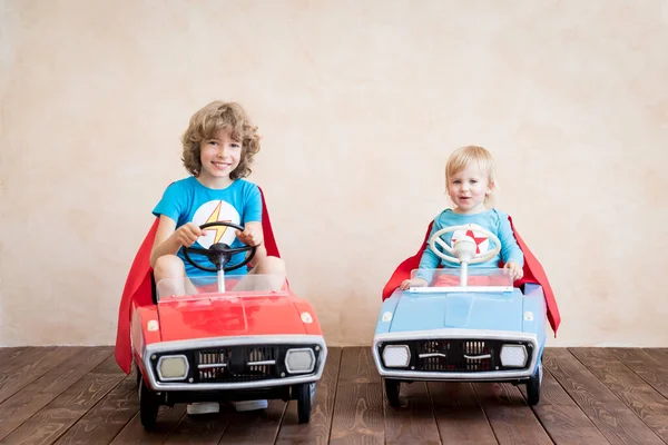 スーパーヒーローの子供たちが家で遊んでいる おもちゃの車を屋内で運転するスーパーヒーローの子供 子供の頃の夢と想像力 — ストック写真