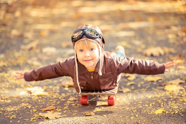 秋の公園で楽しいアウトドアをしている幸せな子供 黄色いぼやけた葉の背景に対して遊んで子供パイロット — ストック写真