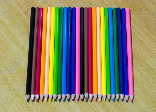 Крупним планом кольорові олівці на старій дерев'яній таблиці — стокове фото
