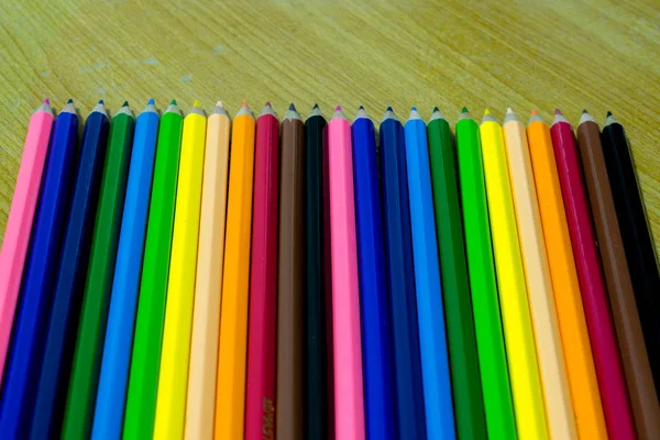 Close up of colored pencils on old wooden tabl — Stock Photo, Image