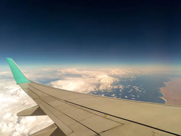 Θέα στη θάλασσα από το παράθυρο του αεροπλάνου κατά την πτήση πάνω από τα σύννεφα — Φωτογραφία Αρχείου