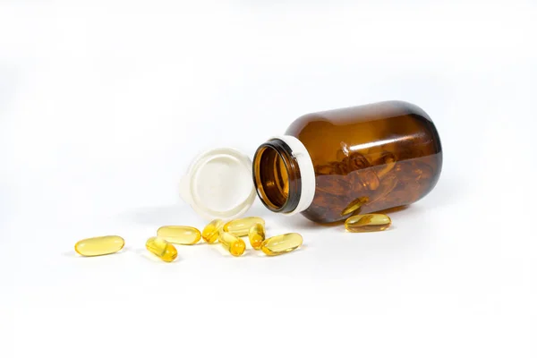 Cápsulas de aceite de pescado con omega 3 y vitamina D en una botella de vidrio, concepto de dieta saludable, aislado sobre un fondo blanco . — Foto de Stock