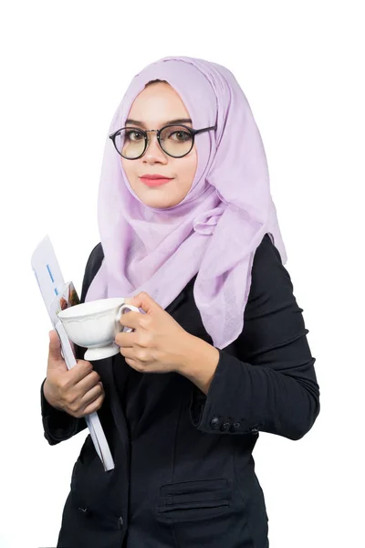 Красивая современная молодая азиатская мусульманская деловая женщина держит чашку кофе и сообщает . — стоковое фото