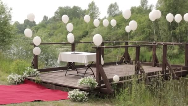 Witte ballonnen op een rivier pier — Stockvideo