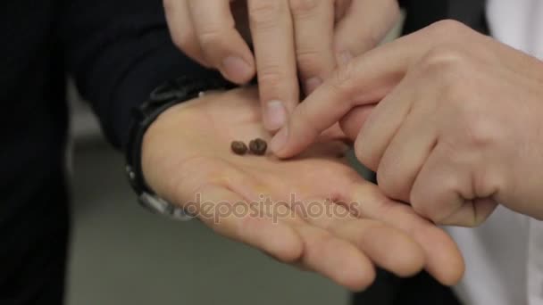 Granos de café en la mano del hombre — Vídeos de Stock