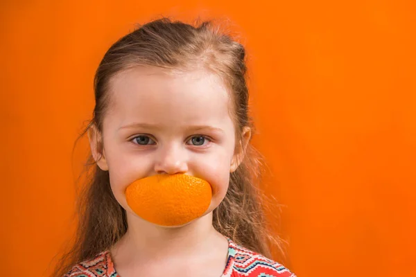 küçük kız bir portakal yemek