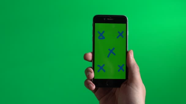 男が探しているタグ付きの緑色の画面マーカー ブラック スマート フォンで上記のクローズ アップ表示 — ストック動画