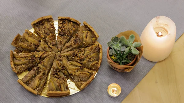 Pasta ev bitkisi ve masanın üzerine mumlar