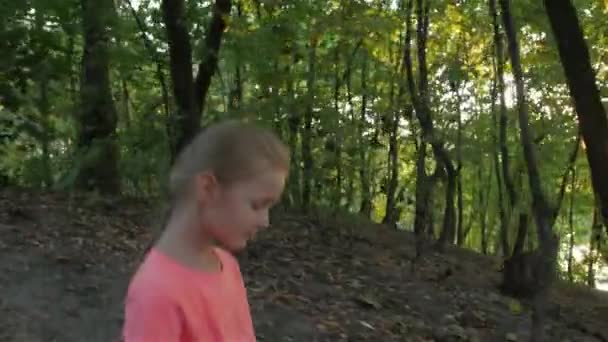 Одна маленькая девочка гуляет по лесу — стоковое видео