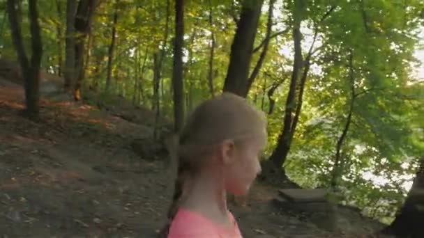 La bambina si guarda intorno nella foresta — Video Stock