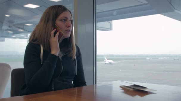 Luchthaven meisje praten over de telefoon — Stockvideo