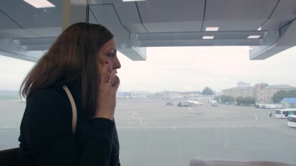 Conversa de menina no telefone no aeroporto — Vídeo de Stock