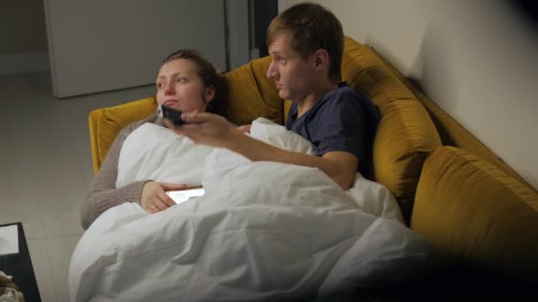 Casal assistindo TV no sofá — Vídeo de Stock