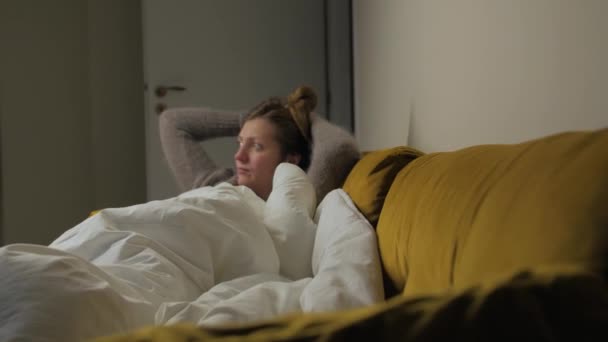 Chica acostarse en el sofá viendo la televisión — Vídeos de Stock