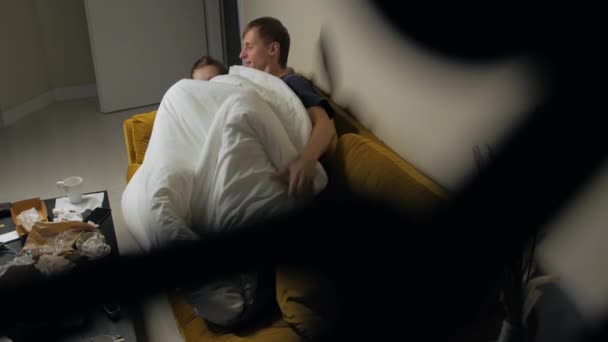 Молодая пара отдыхает на диване — стоковое видео