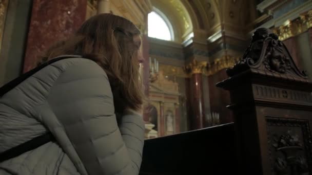 Молодая женщина молится в церкви — стоковое видео