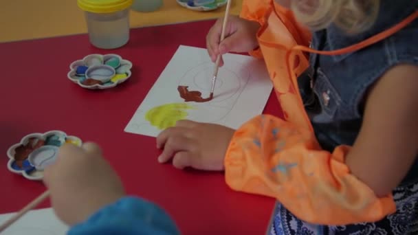 Маленька дівчинка вчиться малювати — стокове відео