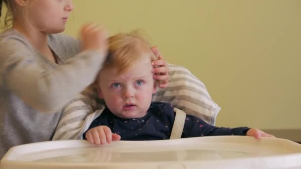 Маленькая девочка заботится о ребенке — стоковое видео