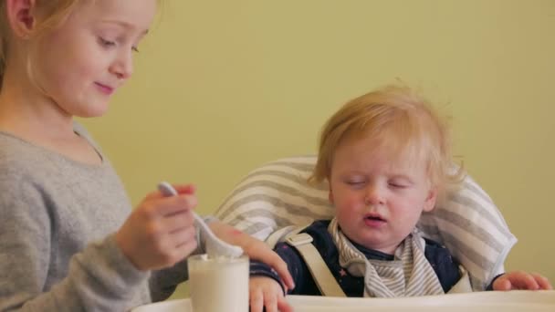 Niña alimenta al bebé — Vídeos de Stock