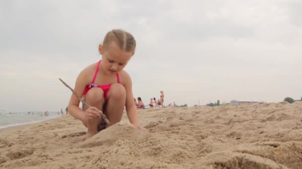 Klein meisje bouwt uit zand — Stockvideo