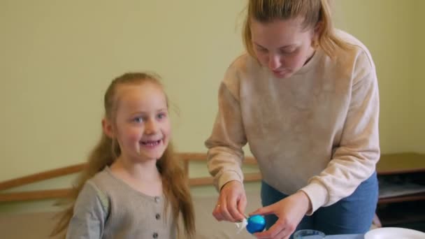 Fille heureuse avec mère peint des oeufs — Video