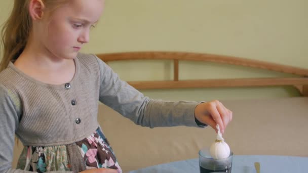 Маленька дівчинка малює яйця — стокове відео