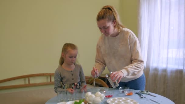 Trauriges Mädchen mit Mutter bemalt Eier — Stockvideo