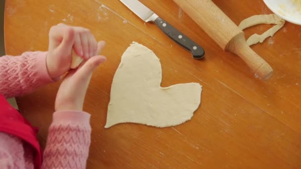 Pequeña niña cortó el corazón de la masa — Vídeos de Stock