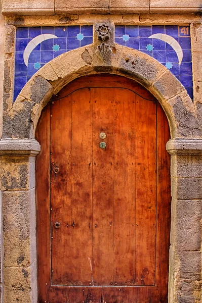 Orange door with blue ceramic in Essaouira, Morocco