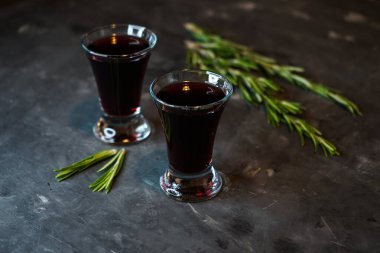 Koyu arkaplanda kiraz, böğürtlen tentürü, biberiye filizi