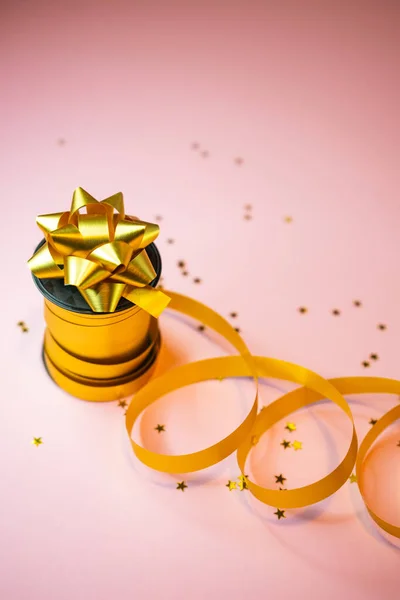 Selectieve focus, gouden cadeau lint op roze achtergrond, copyspace — Stockfoto