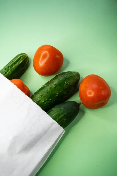 Miljövänligt koncept. Gurkor och tomater i en biologiskt nedbrytbar papperspåse — Stockfoto