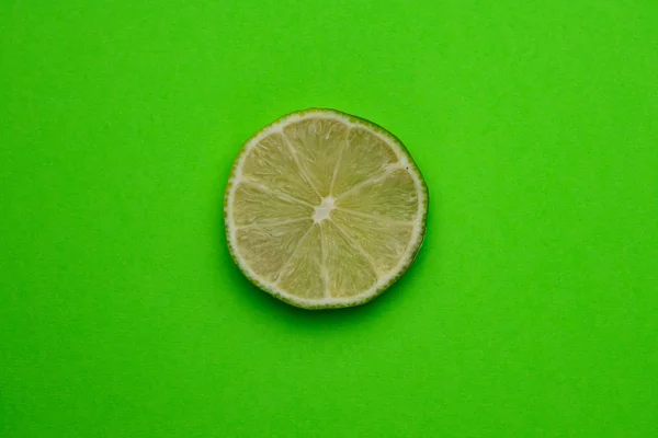 Foco seletivo, uma fatia de limão em um fundo liso — Fotografia de Stock