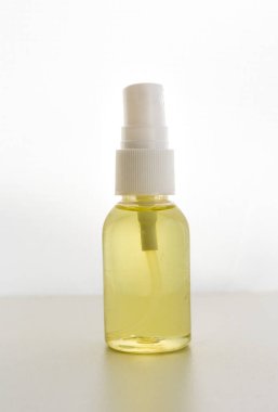 seçici odak, şeffaf plastik sprey kavanozu vücut, yüz veya saç için sarı kozmetik yağı