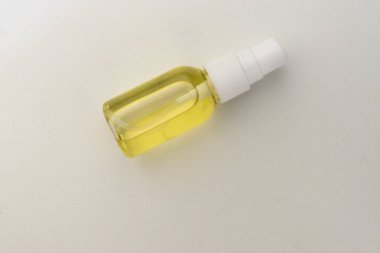 seçici odak, şeffaf plastik sprey kavanozu vücut, yüz veya saç için sarı kozmetik yağı