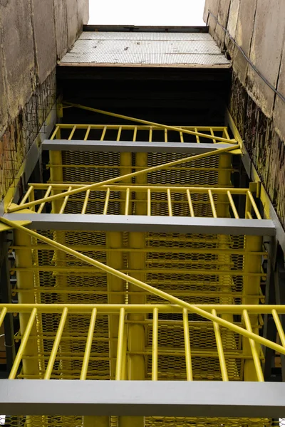 modern metal staircase, futurism, underground, with yellow fences, fire exit in the building