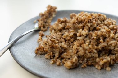 Büyük, güzel gri bir tabakta pişmiş karabuğday.