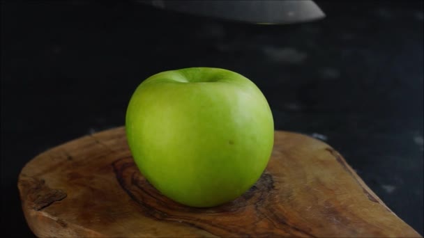 女性的手 锐利地切割一个苹果与刀 在木板上 在黑暗背景下 — 图库视频影像