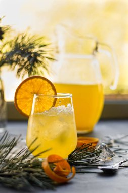 seçici odak, portakal ferahlatıcı ev yapımı limonata buz ve meyve dilimleriyle, karanlık bir masanın üzerinde konturlu bir ışıkta.