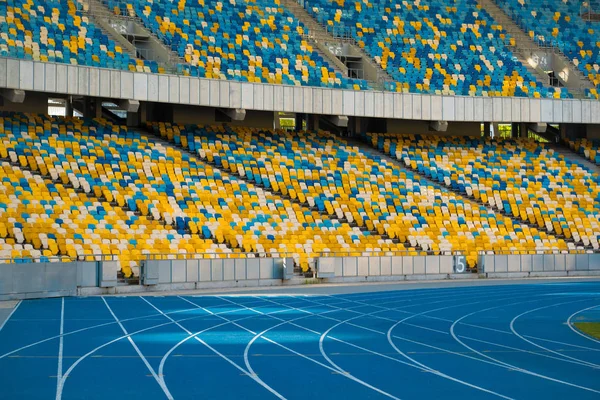 Vacía asientos de estadio coloridos y pistas de atletismo . —  Fotos de Stock