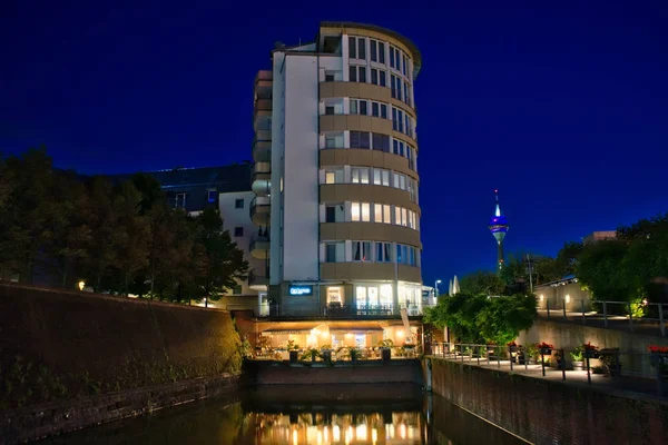 Late evening scene near the Rhine harbor with tower-block and restaurant. Dusseldorf, Germany