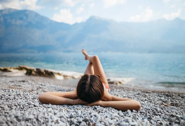 Çakıl plajı üzerinde yatan kadın — Stok fotoğraf